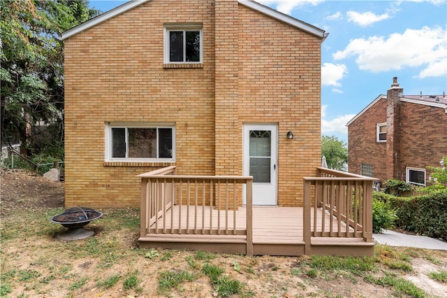 back of house featuring a wooden deck and an outdoor fire pit