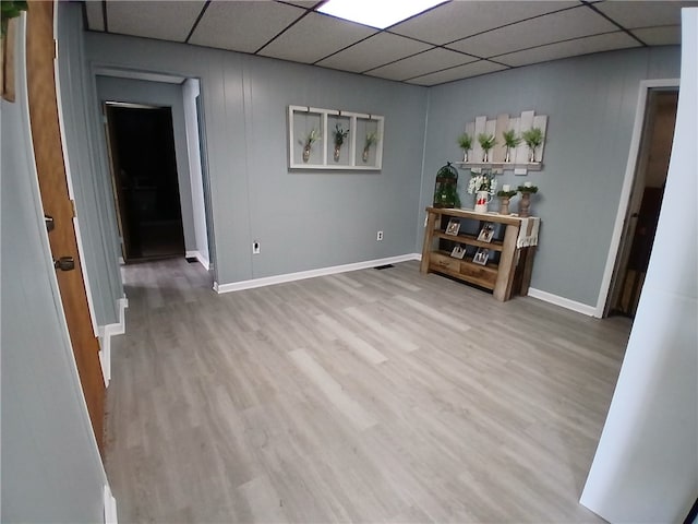 unfurnished room with hardwood / wood-style flooring and a drop ceiling