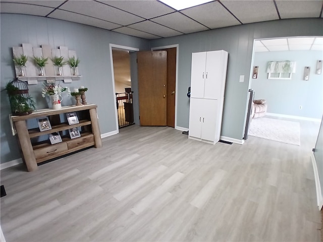 interior space with a paneled ceiling and light hardwood / wood-style flooring