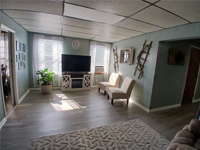 living room with wood-type flooring and a drop ceiling