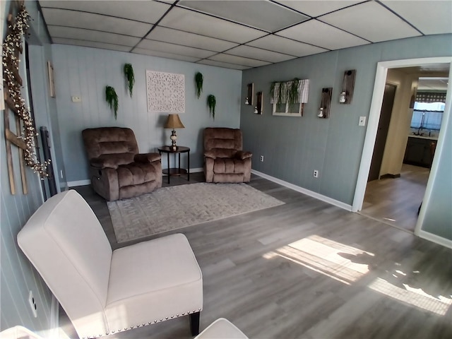 living room featuring hardwood / wood-style floors and a drop ceiling