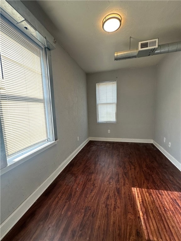 unfurnished room featuring a wealth of natural light and wood-type flooring