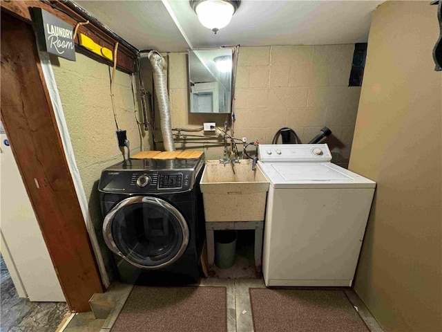 clothes washing area with washer and clothes dryer and sink