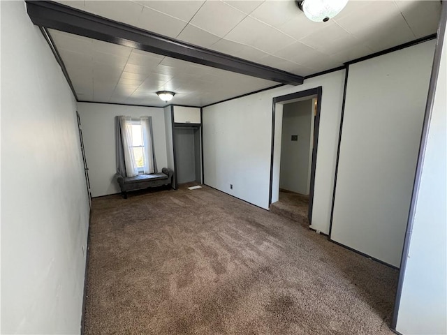 unfurnished bedroom with carpet and beamed ceiling