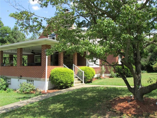 exterior space featuring a front yard and ceiling fan