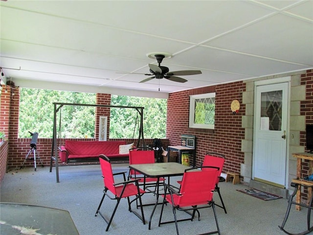 dining room featuring brick wall and ceiling fan