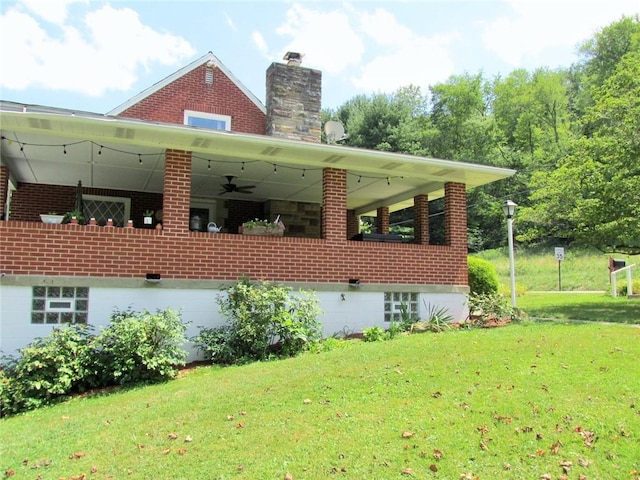 rear view of house with a yard and ceiling fan