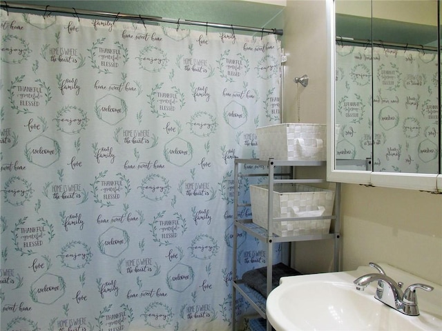 bathroom featuring a shower with shower curtain and sink