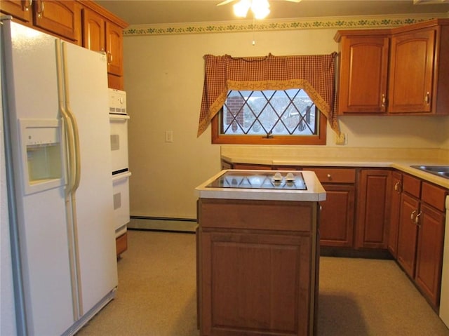 kitchen with white appliances, a baseboard radiator, and light carpet