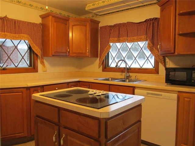 kitchen featuring sink, black appliances, and a healthy amount of sunlight