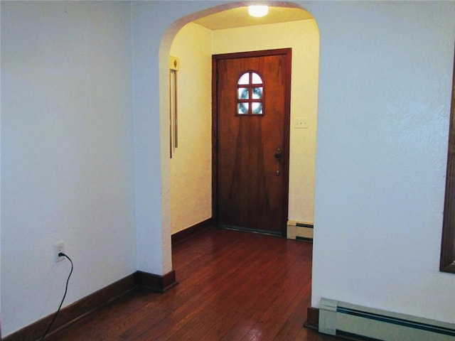 interior space with dark wood-type flooring and baseboard heating