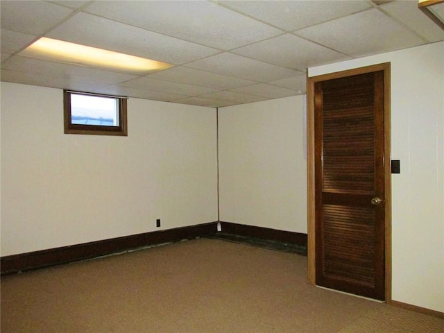 basement with a paneled ceiling and carpet flooring