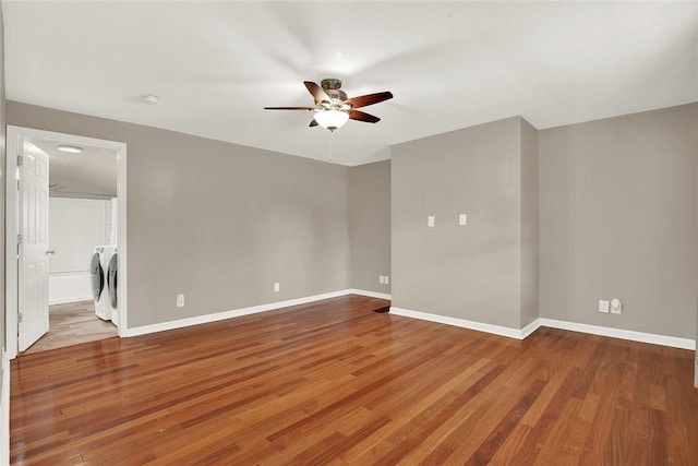 spare room featuring hardwood / wood-style flooring, ceiling fan, and separate washer and dryer