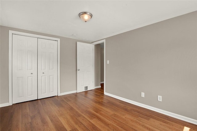 unfurnished bedroom with hardwood / wood-style flooring and a closet