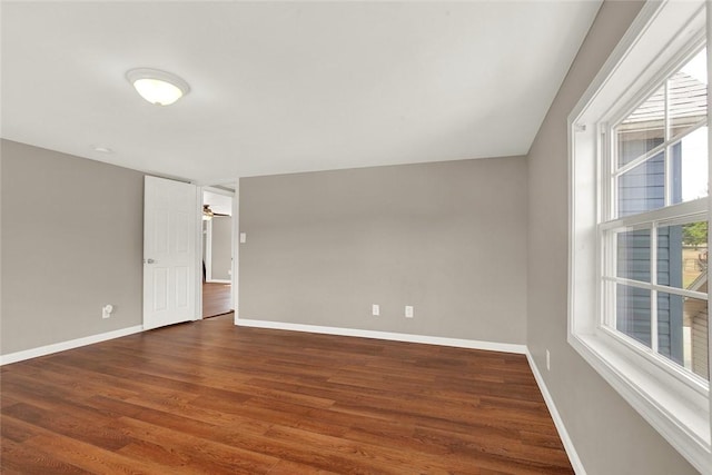 spare room with dark hardwood / wood-style flooring and ceiling fan