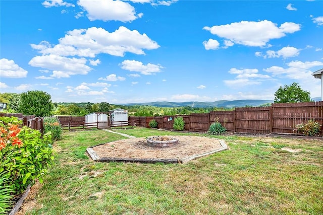 view of yard featuring a mountain view and an outdoor fire pit