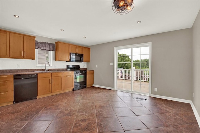 kitchen with sink, black appliances, and dark tile patterned floors