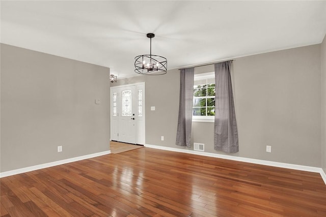 interior space with a notable chandelier and hardwood / wood-style flooring