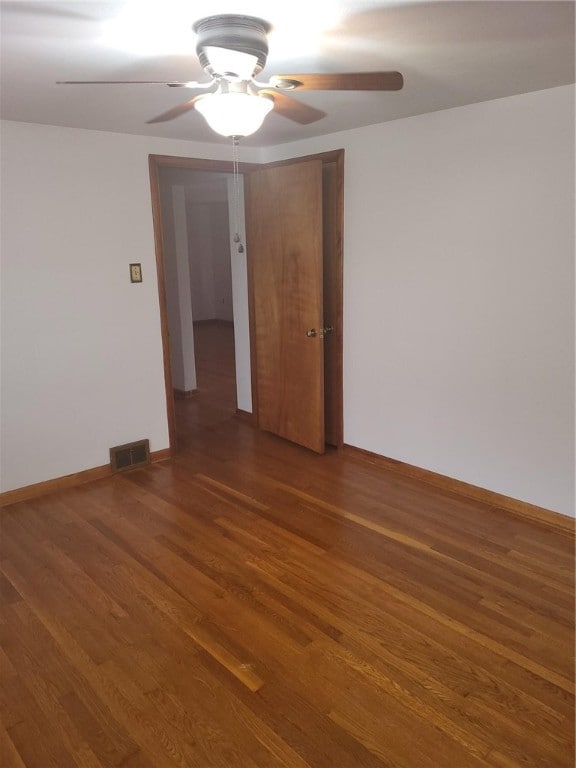 unfurnished room featuring ceiling fan and dark hardwood / wood-style flooring