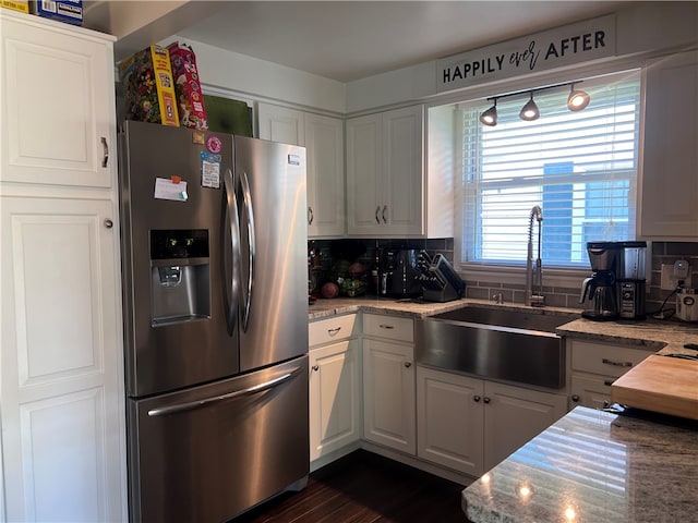 kitchen featuring sink, decorative backsplash, white cabinets, and stainless steel refrigerator with ice dispenser