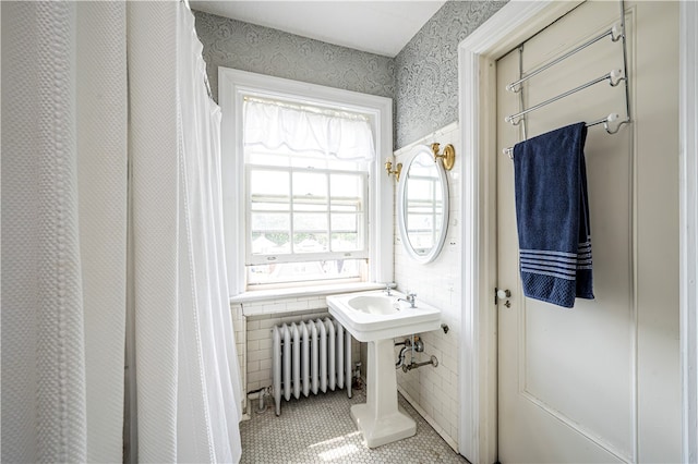 bathroom featuring tile patterned floors, tile walls, and radiator