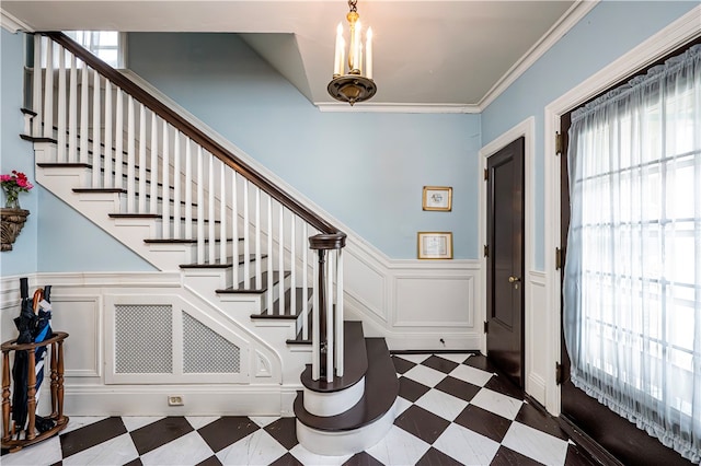 entrance foyer featuring crown molding and dark tile patterned flooring