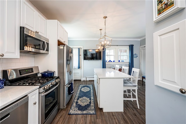 kitchen with tasteful backsplash, stainless steel appliances, dark hardwood / wood-style flooring, a center island, and a breakfast bar area