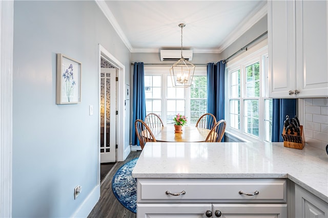 kitchen with an AC wall unit, dark wood-type flooring, crown molding, and light stone counters