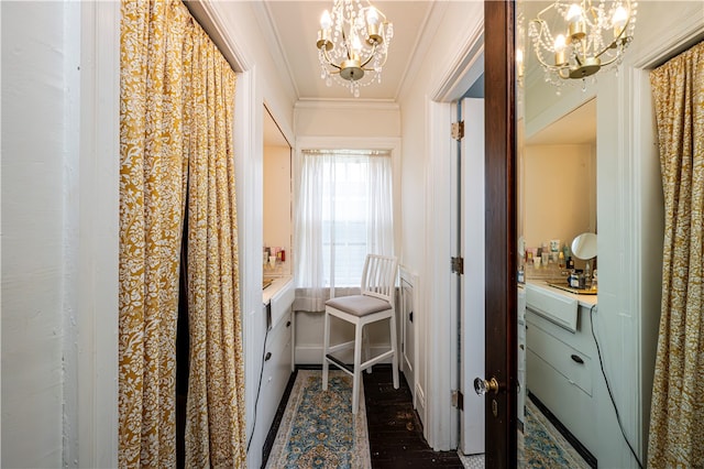 corridor featuring ornamental molding, dark hardwood / wood-style flooring, and a notable chandelier