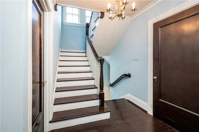 stairs featuring ornamental molding, an inviting chandelier, and hardwood / wood-style floors