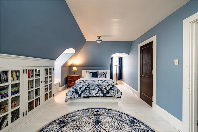 bedroom with vaulted ceiling and light wood-type flooring