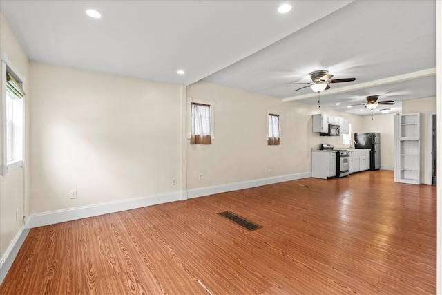 unfurnished living room with light wood-type flooring and ceiling fan