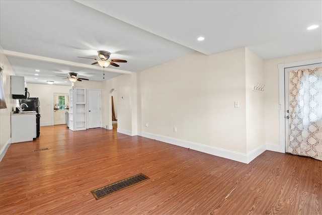 unfurnished living room featuring ceiling fan and light wood-type flooring