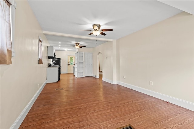 unfurnished living room featuring light wood-type flooring and ceiling fan