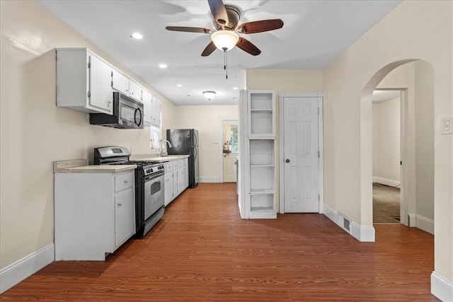 kitchen featuring wood-type flooring, ceiling fan, white cabinetry, and black appliances