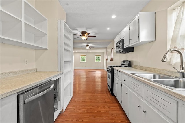 kitchen featuring ceiling fan, sink, white cabinetry, appliances with stainless steel finishes, and light wood-type flooring