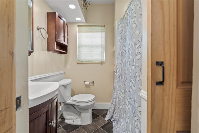 bathroom featuring walk in shower, vanity, tile patterned flooring, and toilet