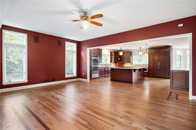 unfurnished living room featuring light hardwood / wood-style flooring and ceiling fan