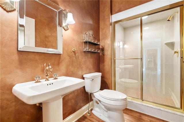 bathroom with wood-type flooring, toilet, and a shower with shower door