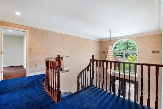 staircase featuring a notable chandelier, carpet flooring, and ornamental molding