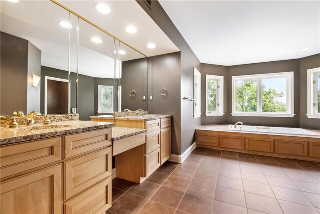 bathroom featuring a tub, vanity, and tile patterned flooring