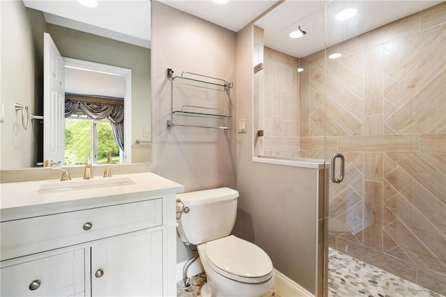 bathroom featuring toilet, walk in shower, and vanity