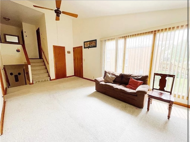 living room with light carpet, ceiling fan, and high vaulted ceiling