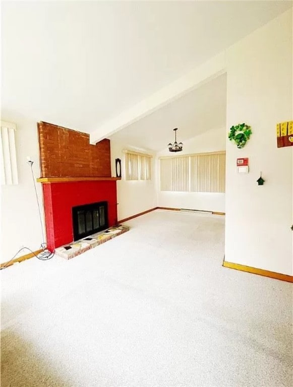 carpeted living room with a fireplace and beamed ceiling