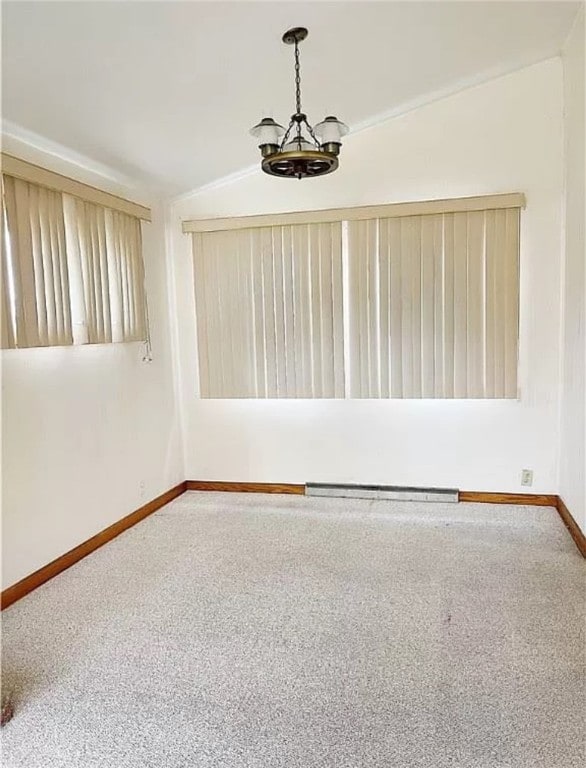 unfurnished room featuring carpet floors, a chandelier, and lofted ceiling