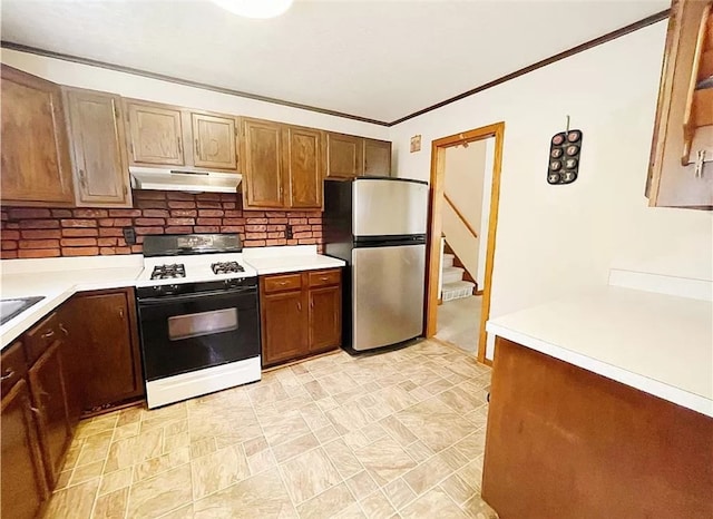 kitchen with light tile patterned flooring, decorative backsplash, stainless steel refrigerator, and white gas range