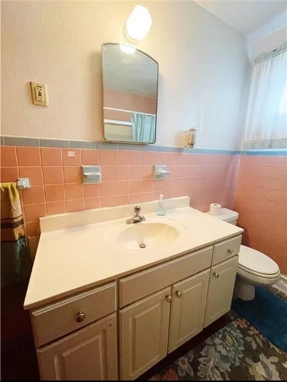 bathroom with vanity, tile walls, toilet, and backsplash