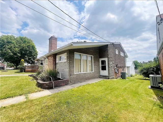 exterior space with central air condition unit and a lawn