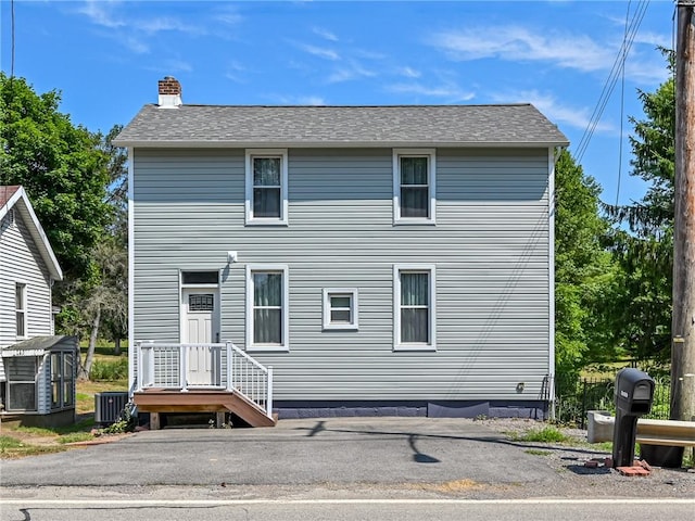 back of house with central air condition unit