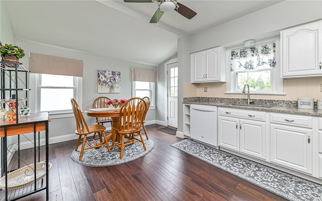 kitchen with dishwasher, white cabinets, stone countertops, and dark wood-type flooring